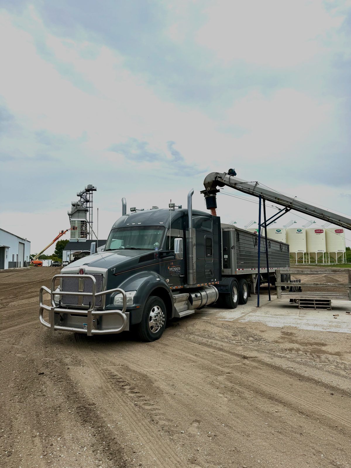 A Moser Brothers grain truck loading under an auger at an elevator